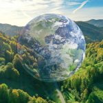 Globe of the world in a natural environment with trees and grass on hills under the daytime sky