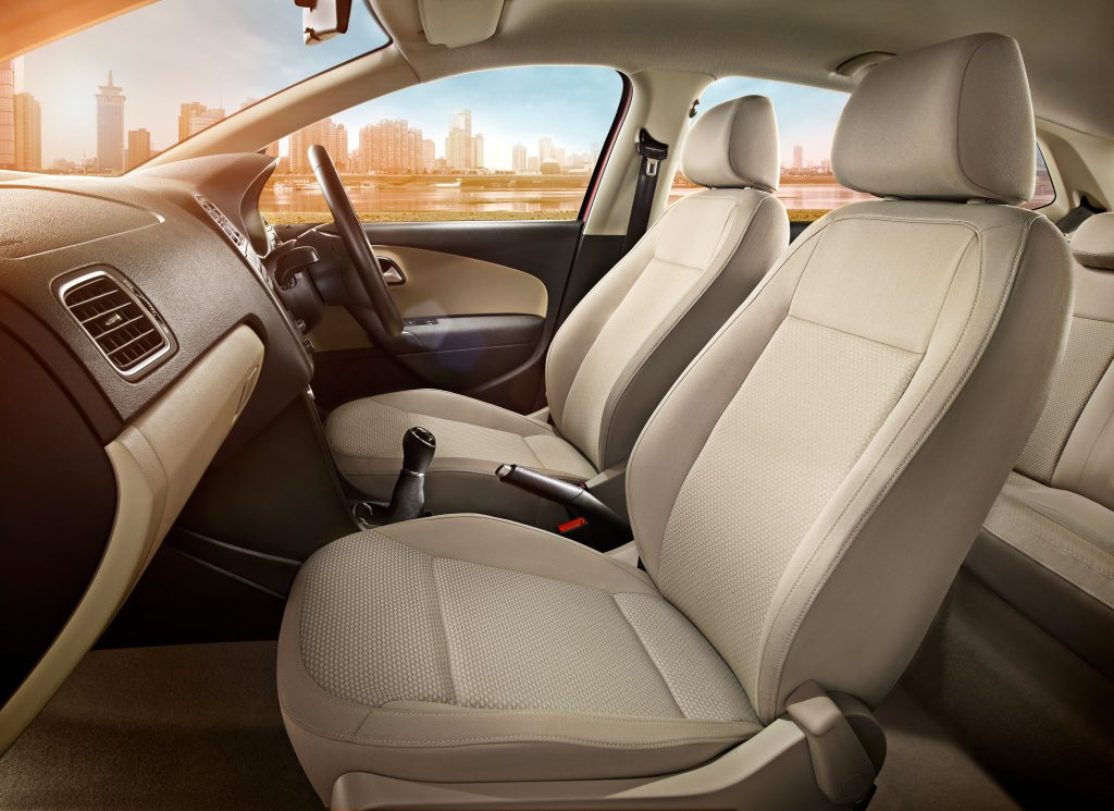 Car interior primarily the front 2 seats, passenger and driver seat behind the steering wheel and dash