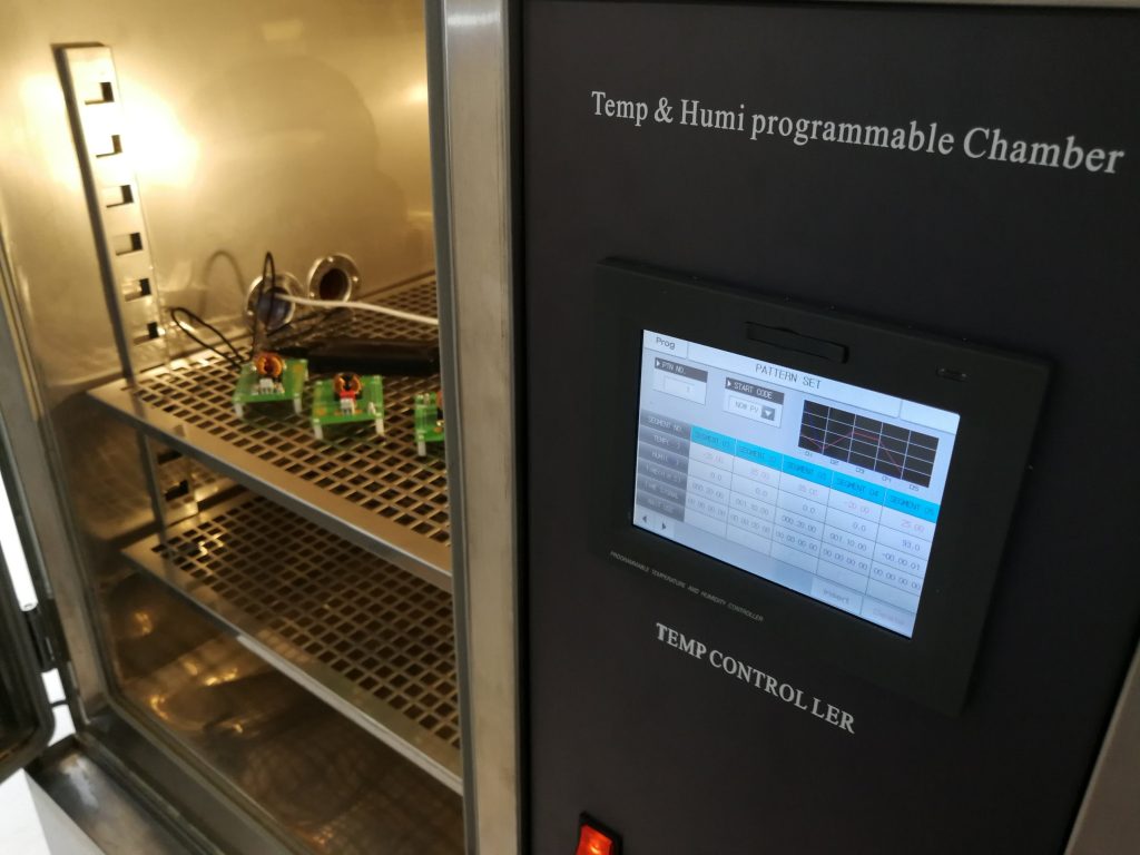Thermal and humidity test chamber with samples on the shelves.